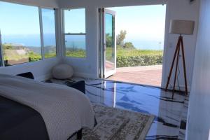 a bedroom with a bed and a view of the ocean at Quiet Mountain Vineyard Above the Clouds in Malibu