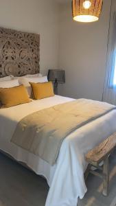 a bedroom with a large white bed with yellow pillows at 3 Bedroom piso in El pueblo de Javea in Jávea