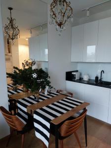 une cuisine avec une table à manger avec un tissu de table rayé noir et blanc dans l'établissement Green Apartment Gdańsk z GARAŻEM, à Gdańsk