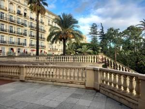 a fence in front of a building with palm trees at Victoria Appartement in Menton