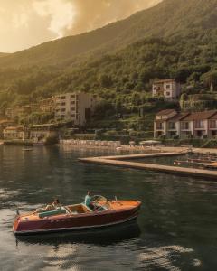 duas pessoas num barco na água em Filario Hotel & Residences em Lezzeno