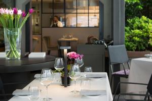 a table with wine glasses and flowers on it at Filario Hotel & Residences in Lezzeno