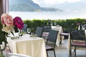 a group of tables with wine glasses and flowers at Filario Hotel & Residences in Lezzeno