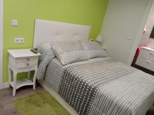 a small bedroom with a bed and a night stand at VIVE CENTRO ASTORGA in Astorga