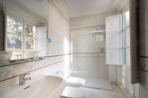 a white bathroom with a toilet and a sink at Miranda & Suizo in San Lorenzo de El Escorial