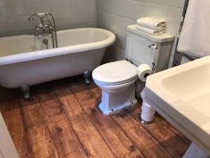 a bathroom with a tub and a toilet and a sink at Heather Bank Cottage, Halifax. Yorkshire. HX2 7DD in Halifax +23 photos