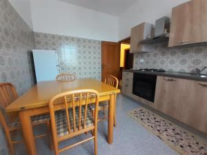 una pequeña cocina con mesa de madera y sillas en Casa Olga, en Pianella