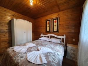 a bedroom with a bed in a wooden cabin at Sitio Recanto Feliz in Gramado