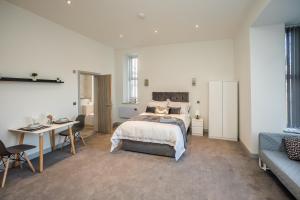 a bedroom with a bed and a desk and a couch at Exquisite Serviced Studio @ Greenhead Central in Huddersfield