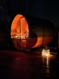 ein rundes Holzgebäude mit Licht im Dunkeln in der Unterkunft Henkieker - ländliche Ferienwohnung mit Stil in Fehmarn