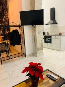 salon z wazą z czerwonymi kwiatami na stole w obiekcie Coco Homes w Madrycie