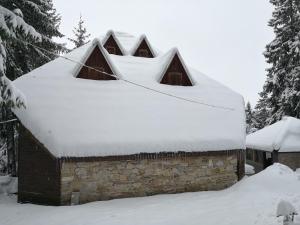 a snow covered roof of a building with snow on it at Vikendica Ajla in Travnik