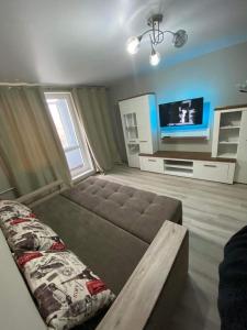 uma sala de estar com um sofá e uma televisão de ecrã plano em Lovely Brand New Apartment with 2 Rooms and Balcony em Chisinau