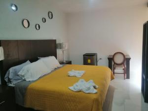 a bedroom with a bed with two towels on it at HOTEL MI HERMOSO DOLORES in Dolores Hidalgo