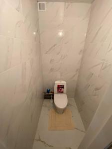 uma casa de banho com WC num quarto com paredes em mármore em Lovely Brand New Apartment with 2 Rooms and Balcony em Chisinau