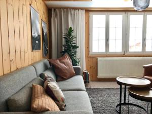 a living room with a couch and tables and windows at Chalet Pironnet with BEST Views, Charm and Comfort! in Lauterbrunnen