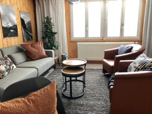 a living room with couches and a table at Chalet Pironnet with BEST Views, Charm and Comfort! in Lauterbrunnen