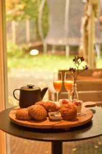 une table avec une assiette de nourriture et deux verres de vin dans l'établissement Boukje har Bêd en Brochje, à Bergum