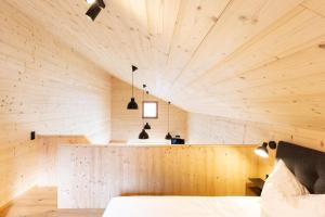 a room with a wooden ceiling and a bed at Masura Cabins in Bürserberg