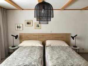 two twin beds in a bedroom with two lamps at Chalet Pironnet with BEST Views, Charm and Comfort! in Lauterbrunnen