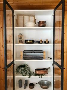 a glass pantry cabinet filled with dishes and utensils at Chalet Pironnet with BEST Views, Charm and Comfort! in Lauterbrunnen