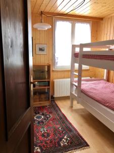 a room with two bunk beds and a rug at Chalet Pironnet with BEST Views, Charm and Comfort! in Lauterbrunnen