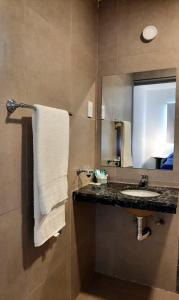 uma casa de banho com um lavatório e um espelho em Hotel Musto em Rosário
