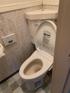 a bathroom with a toilet with the lid up at 山下ビル５０１ in Sutara