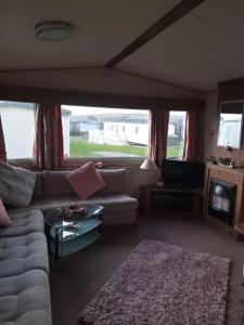 a living room with a couch and a tv at Summer Breeze in Bude