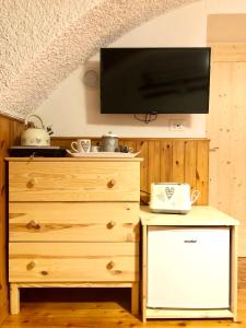 1 dormitorio con vestidor y TV en la pared en La stube degli sciatori en Serrada