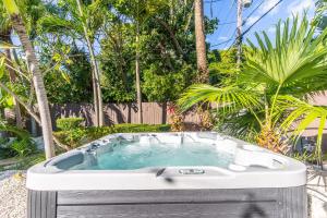 a hot tub in a yard with palm trees at NEWLY RENOVATED POOL, HOT TUB, & EPIC BACKYARD in Fort Lauderdale