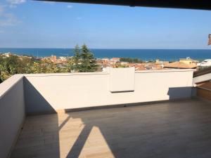 a white bench on a balcony with a view of the ocean at Appartamento B&B Orizzonti in Porto SantʼElpidio
