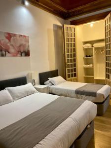 een slaapkamer met 2 bedden en een plank met borden bij Nice Dreams House in Madrid