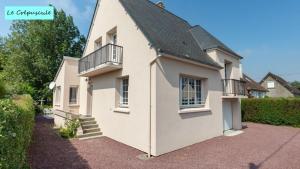 Cette maison blanche dispose d'un balcon sur le côté. dans l'établissement Le Crépuscule, 300m de la plage, animaux de compagnie bienvenue, à Gouville-sur-Mer