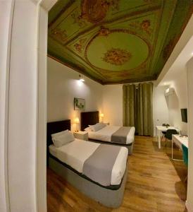 2 bedden in een hotelkamer met een plafond bij Nice Dreams House in Madrid