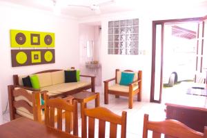Casa Duplex 3 Suítes em Condomínio في بورتو سيغورو: غرفة معيشة مع أريكة وكراسي وطاولة