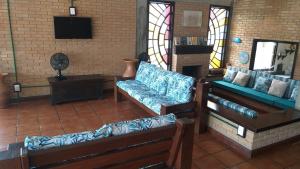 a living room with two couches and a television at Santa Paula - Cocanha - De frente para a Praia in Caraguatatuba