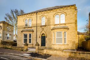 an old brick house with a fire hydrant in front of it at Exquisite Serviced Studio @ Greenhead Central in Huddersfield