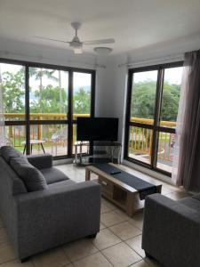 ein Wohnzimmer mit zwei Sofas und einem Fernseher in der Unterkunft Coral Towers Holiday Suites in Cairns