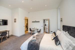 a bedroom with a large bed and a table with chairs at Exquisite Serviced Studio @ Greenhead Central in Huddersfield