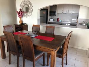 cocina y comedor con mesa de madera y sillas en Coral Towers Holiday Suites en Cairns