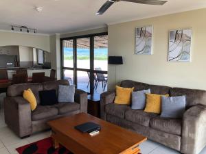 een woonkamer met 2 banken en een tafel bij Coral Towers Holiday Suites in Cairns