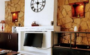 salon z telewizorem i zegarem na ścianie w obiekcie Appartement Panier Vieux port w Marsylii