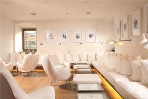 - une salle d'attente avec des tables et des chaises blanches dans l'établissement Hotel Continentale - Lungarno Collection, à Florence