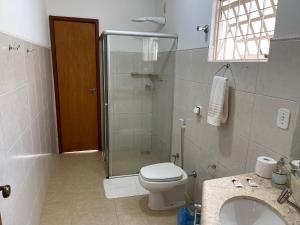 een badkamer met een douche, een toilet en een wastafel bij Pousada Xero in Capitólio