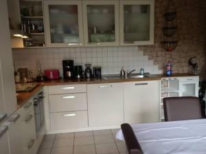 a kitchen with white cabinets and a sink at Haus Bergrose in Busenborn