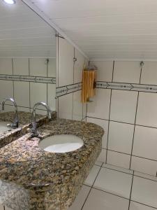 a bathroom with a sink with two faucets at Casa Oliveiras in Itajaí