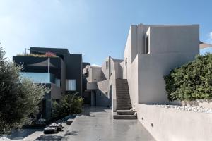 a white building with stairs on the side of it at West East Suites in Imerovigli