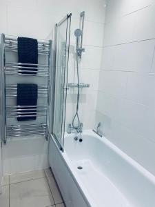 a white bathroom with a tub and a shower at CENTRAL LOCATION Modern North Lanes Holiday Cottage with a Private Patio in Brighton & Hove