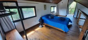an overhead view of a bedroom with a blue bed at IbiraCottage in Imbituba